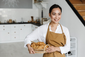Smiling attractive young asian woman wearing apron