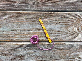 On a yellow wooden stick wrapped yarn, children's craft