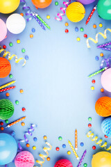 Birthday party background on violet. Frame made of colorful serpentine, balloons, candles and candies, top view.