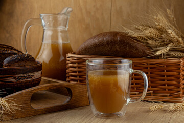 Homemade bread kvass. Summer carbonated soft drink. Glass and carafe on a wooden table. Black...