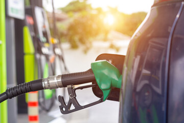 Car gas nozzle auto filling refuel fill up with premium petrol gasoline at gas station. Close up.