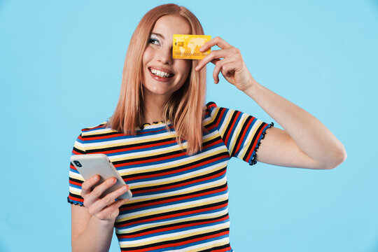 Image of laughing woman using cellphone and holding credit card