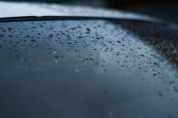 Water droplet on the car hood. Water beading after rain or car wash on white shiny paint surface....
