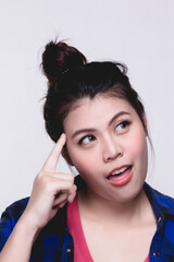 Young woman thinking, using finger pointing on head over white background.