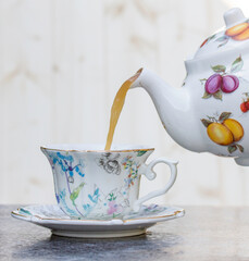 An English afternoon cup of tea poured from a teapot 