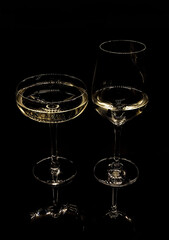 .two glasses with white wine on a black background