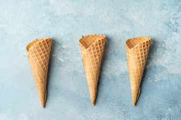empty ice cream cones on a blue background with copy space