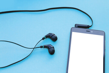 Mockup smartphone and earphones on blue background.