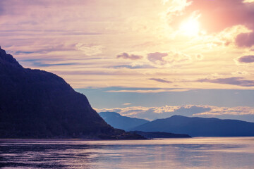 Mountain range on the horizon. Rocks in the sea at sunset. Beautiful rocky seascape in the evening. Wilderness, beautiful nature of Norway, Europe