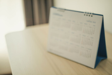 Obraz premium Blur calendar page close up on wood table background business planning appointment meeting concept