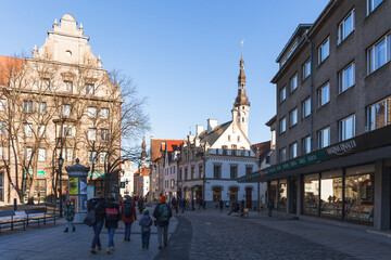 Naklejka premium TALLINN, ESTONIA - DECEMBER 26, 2018: Tourists at street in old town. Sunny day.