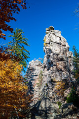 Autumn forest and big rock Dratenik near Malinske Skaly. Rock climbing in Bohemian Moravina Highlands, Žďár Hills, Vysocina, Czech Republic.