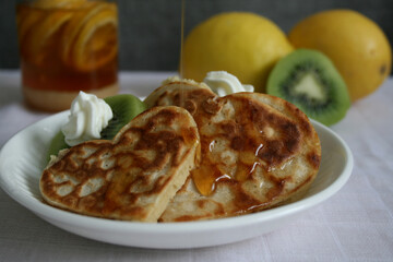 Heart shape pancakes with cream and kiwi