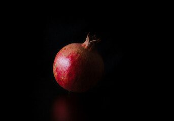 Ripe pomegranate on a black background