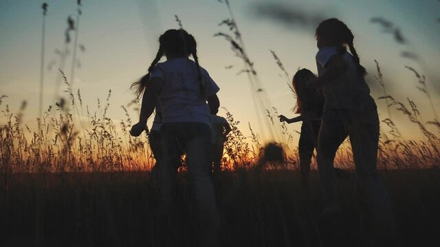 happy family children kids together run in the park at sunset silhouette. people in the park concept mom dad daughter and son lifestyle joyful run. parents and little baby child fun summer vacation