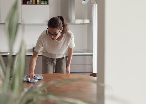 Woman cleaning the kitchen table with a cloth