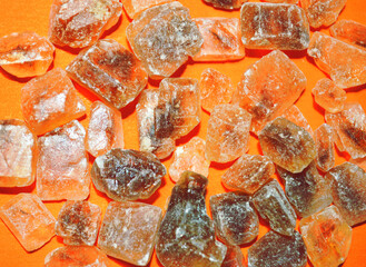 Closeup of caramel sugar cubes against orange background 