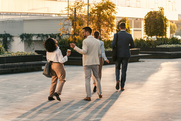 Obraz premium Group of business people walking outside in front of office buildings.