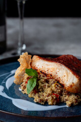Close up of roasted fish with couscous and blueberry sauce, fine dining meal in a restaurant