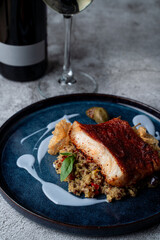 Close up of roasted fish with couscous and blueberry sauce, fine dining meal in a restaurant