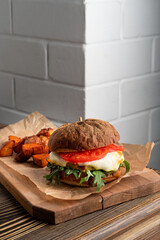 Gourmet vegetarian burger with melted cheese and baked sweet potato