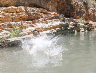 Fototapeta na wymiar Paradise Valley Agadir Morocco. The boy jumps into the lake.