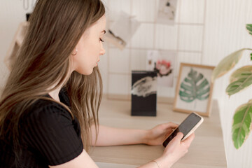 Young girl sitting on a chair with smartphone