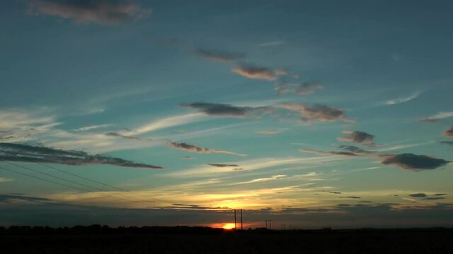 The sun setting sky clouds in the UK countryside. Time lapse shot.