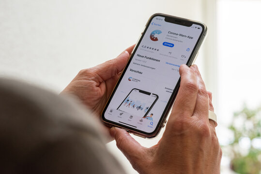 Ostfildern, Germany - June 16, 2020: A middle aged woman is about to download the new smartphone app to combat the corona pandemic on her Apple iPhone 11 Pro. The app is comissioned from the German