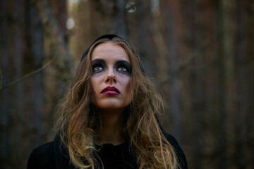 Naklejka premium girl witch witch in a dark pine forest