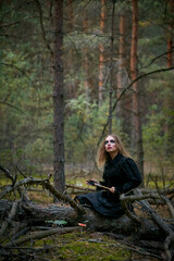 Fototapeta na wymiar girl witch witch in a dark pine forest