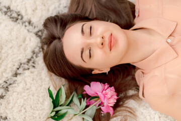 Obraz na płótnie Canvas young woman lying on floor with flower