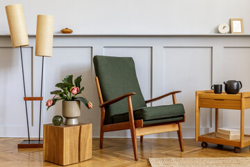 Minimalistic composition at living room interior with design green armchair, beige lamp, flowers,...