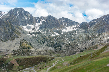Obraz premium Sunny day with low clouds in the town of Pas de la Casa on the border between France and Andorra in June 2020. and Andorra in June 2020.