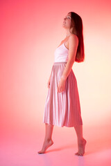 Glamour young woman in pink dress, girl, lady, model on pink background 