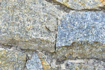 Gray blue old wall made of colored stones and cement
