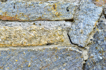 Gray blue old wall made of colored stones and cement