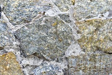 Gray blue old wall made of colored stones and cement