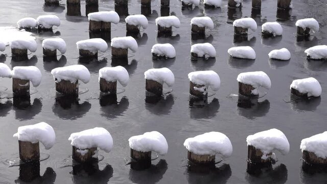 Amazing snow figures from the stuck snow formed on wood stilts in the middle of the river. You can see that the snowstorm is chalk from left to right
