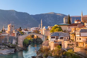 Papier Peint photo Tower Bridge Skyline of Mostar with the Mostar Bridge, houses and minarets, at the sunset in Bosnia and Herzegovina