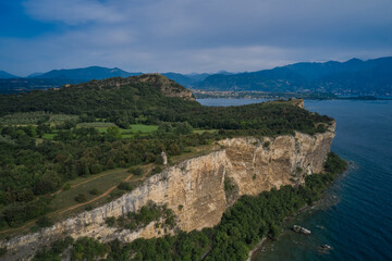 Fototapeta na wymiar Lake Garda, Italy. Aerial view of high speed department tollbooth, rocca di manerba in the background mountains, cumulus clouds at high altitude