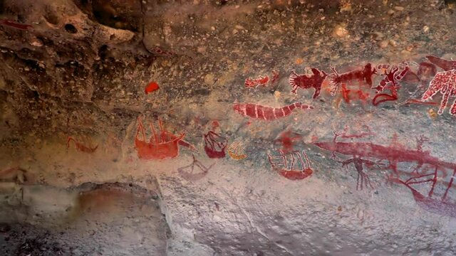 Panning shot of red petroglyphs on rock formation in cave - Great Barrier Reef, Stanley Island