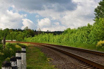 Fototapeta na wymiar Railroad curve on summer bright cloudy day
