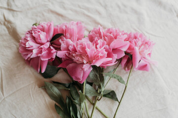 pink peonies on the table with a cup of tea