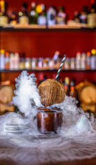 Smoked cocktail in coconut shell, on bar background