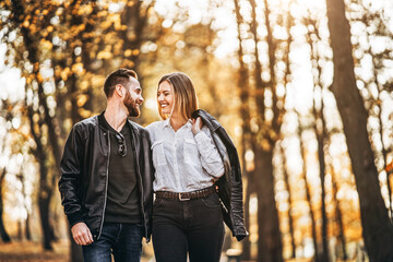 Fototapeta premium Portrait of a happy loving couple walking outdoor in the autumn park