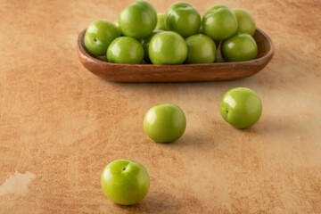 closeup fresh and ripe green plums on a table