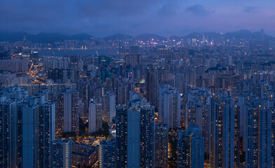 Crowded city with lights turning on and off at night. Hong Kong city apartment buildings at night. 