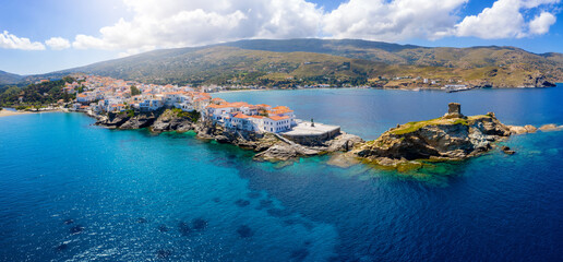 Panoramic aerial view to the town of Andros island, situated on rocks above the turquoise sea, Cyclades, Greece
