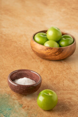 closeup fresh ripe green plums on a table served with salt